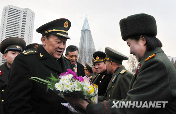 11月22日，中国国务委员兼国防部长梁光烈（左）在平壤祖国解放战争胜利纪念塔广场接受献花。新华社记者姚西蒙摄