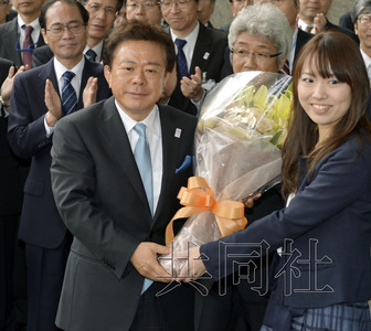 12月18日，高票当选东京都新知事的猪濑直树正式到任。图为猪濑从政府职员手中接过花束。(共同社)