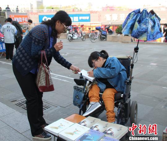 洛洛正在给买书的顾客签名。 冯晓林 摄