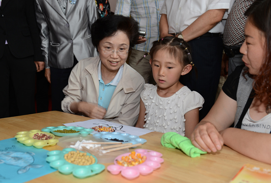 宋秀岩在白石口村儿童快乐家园参与孩子们的豆画创作活动。记者 徐建军 摄